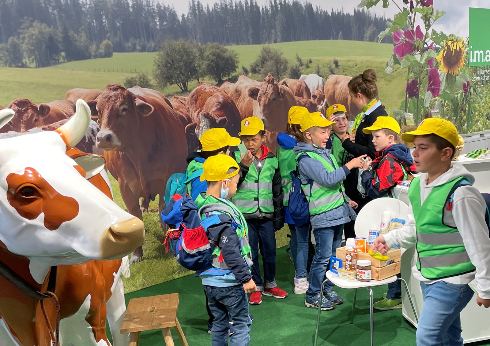 Kinder am Messestand vor einer Kunstkuh