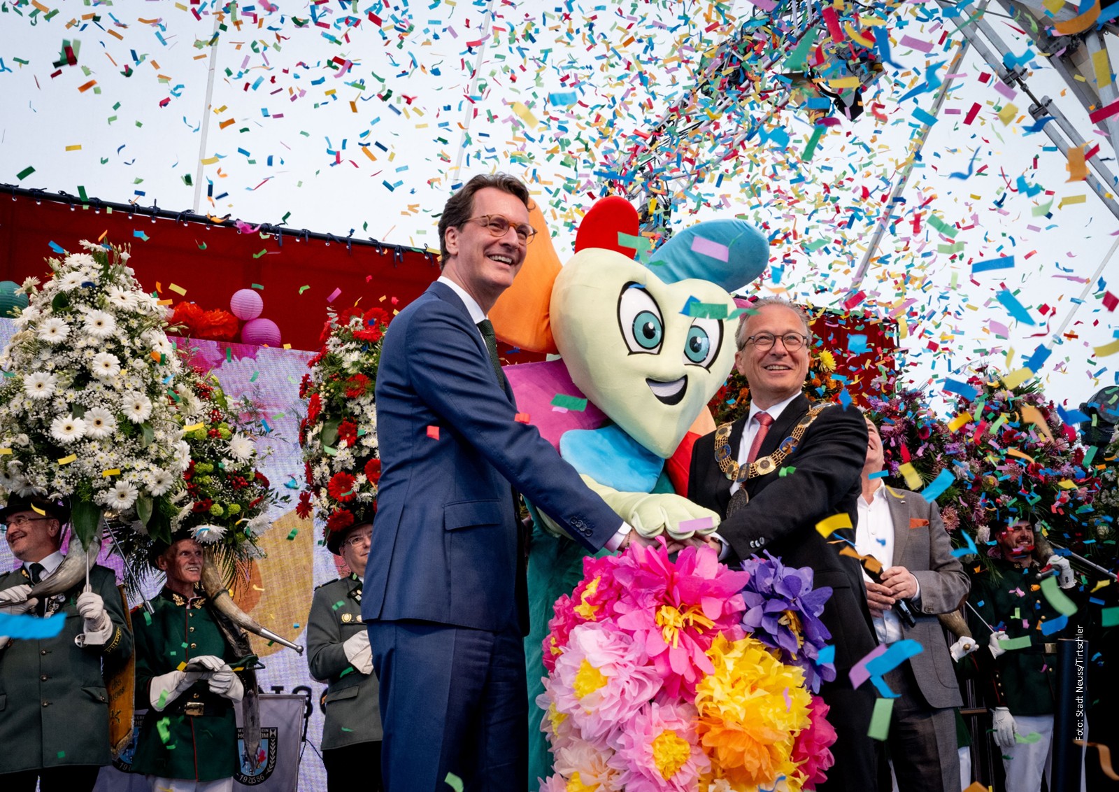 NRW-Ministerpräsident Wüst und Neuss' Bürgermeister Reiner im Konfettiregen bei der Eröffnung der Landesgartenschau.